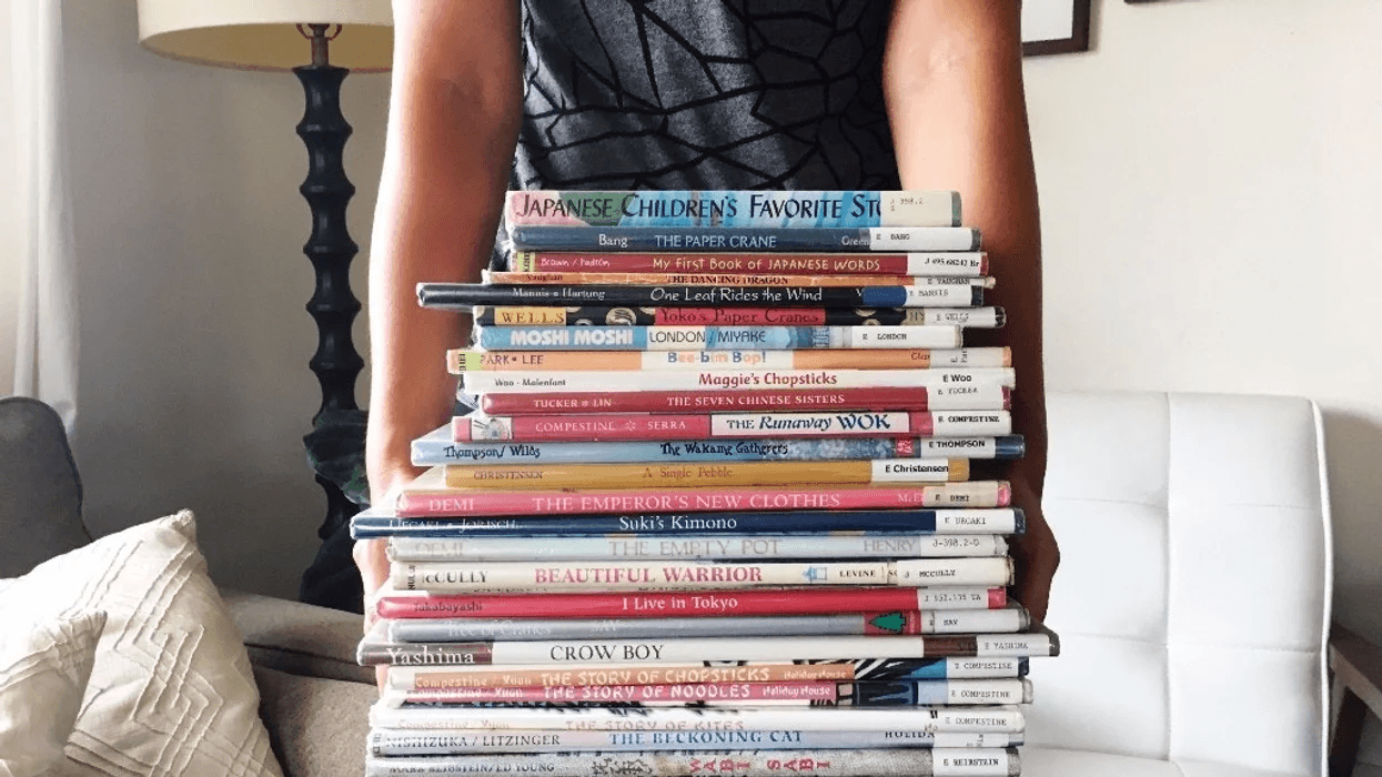 child carrying stack of books