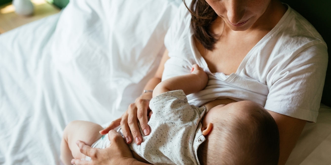 woman breastfeeding baby - breastfeeding is a full time job