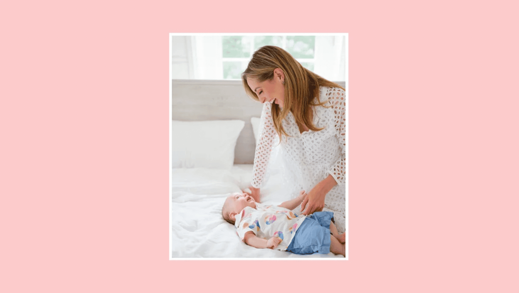 eva amurri standing over her baby on a bed