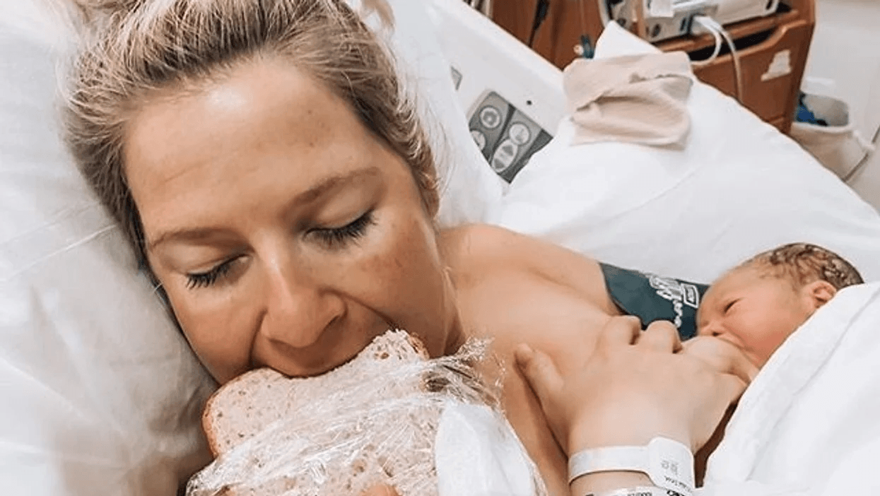 mom taking a bite of deli sandwich while baby breastfeeds after giving birth