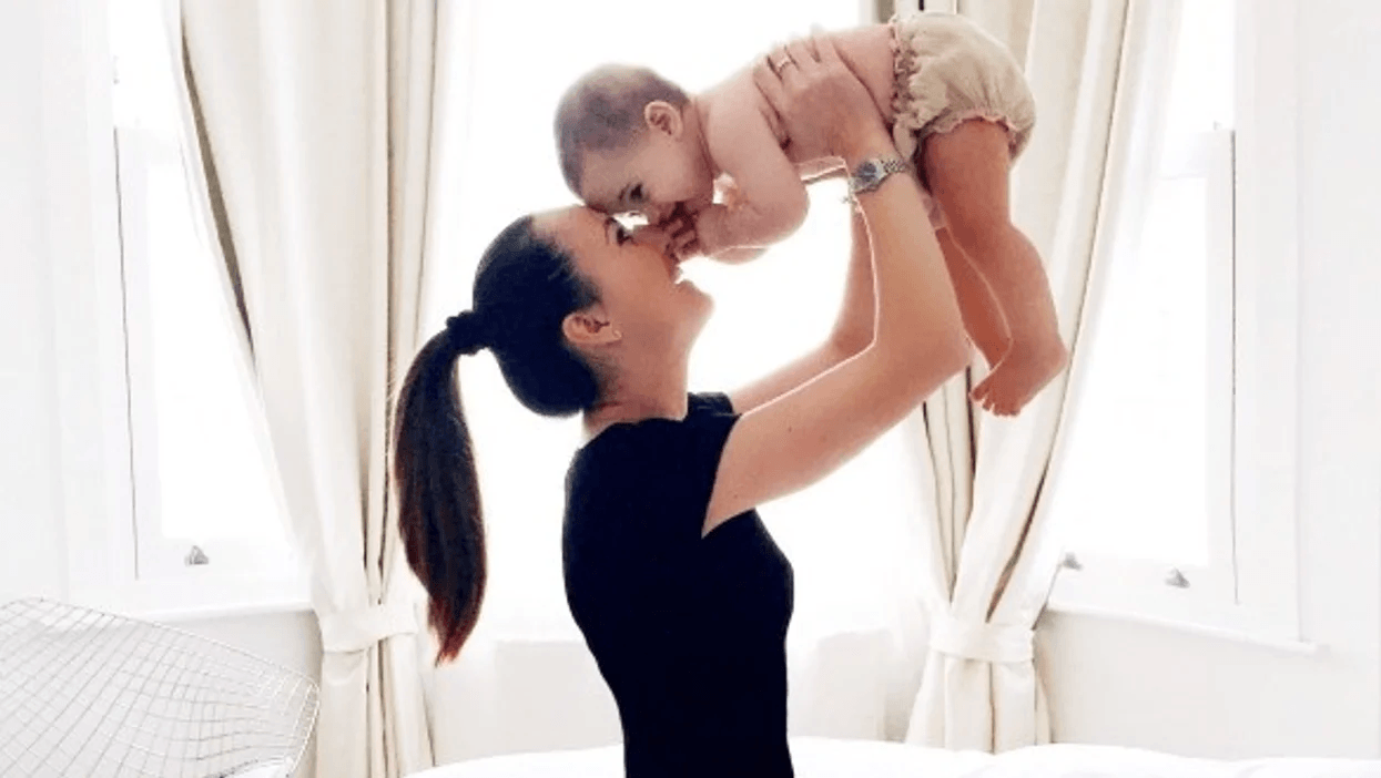 mom playing with baby holding her above her head