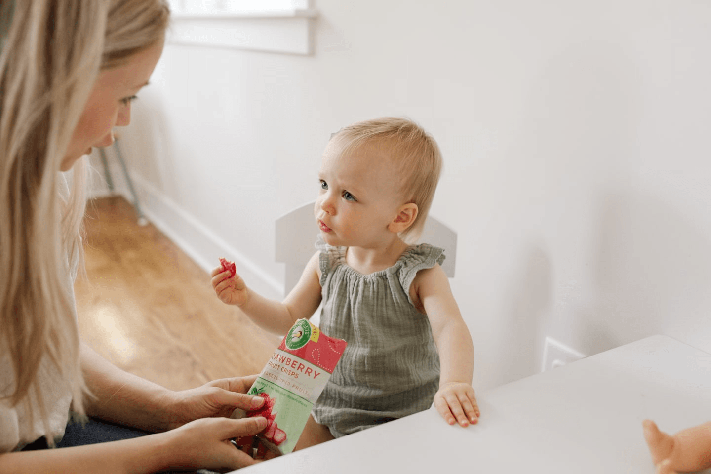 mom feeding a toddler a pouch