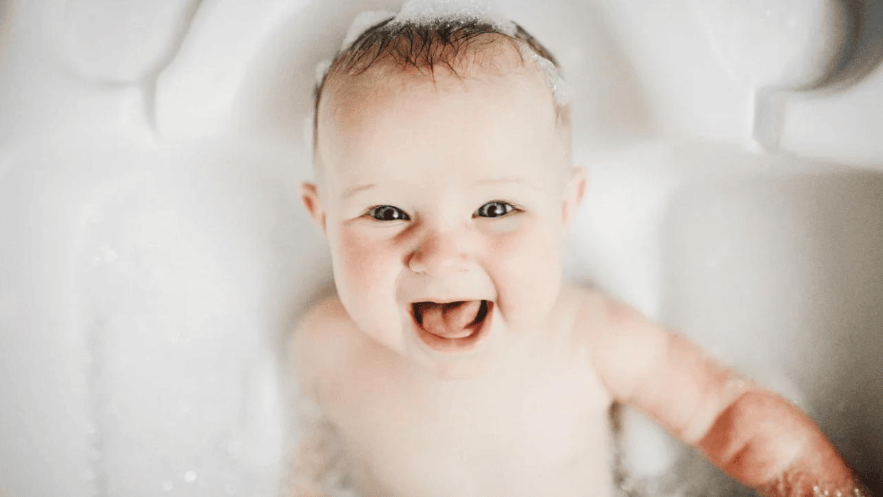 baby smiling in a bubble bath
