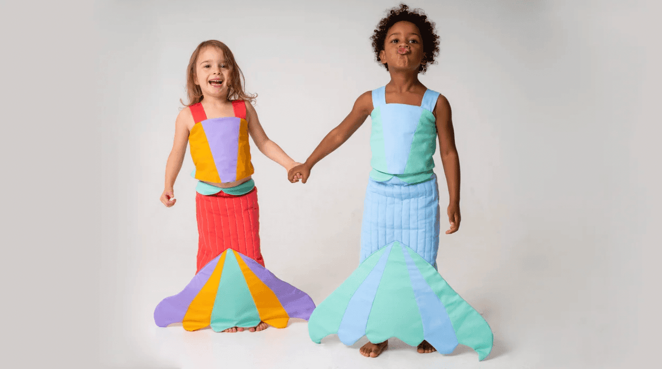 two girls wearing mermaid costumes