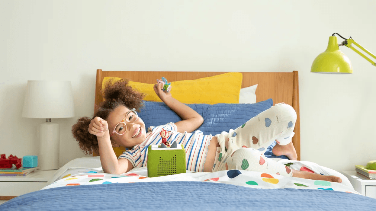 little girl playing with Toniebox