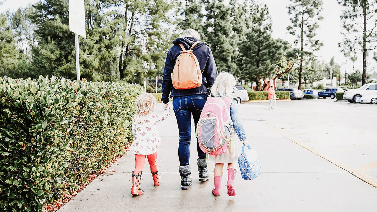 mom walking two daughters into school