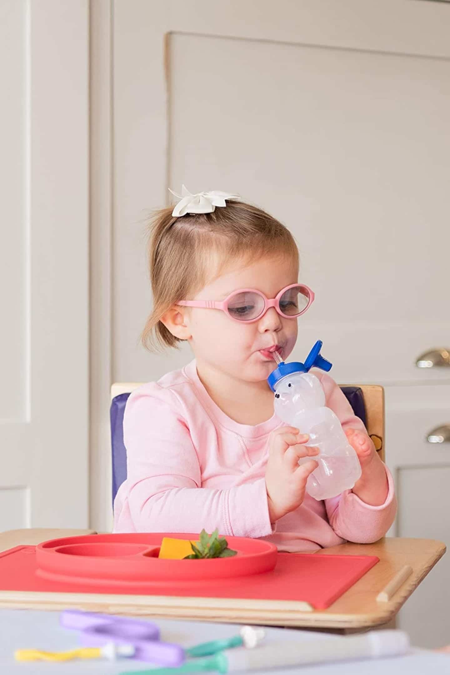 child drinking from straw cup