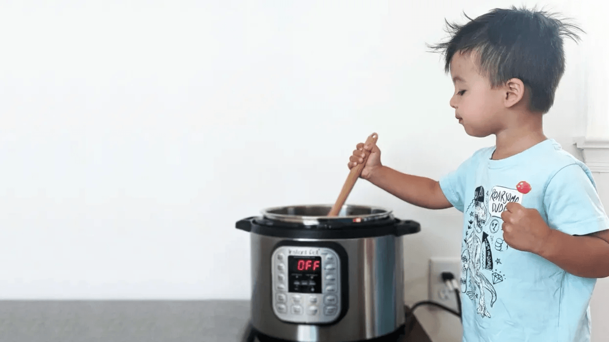 toddler stirring food in an instant pot