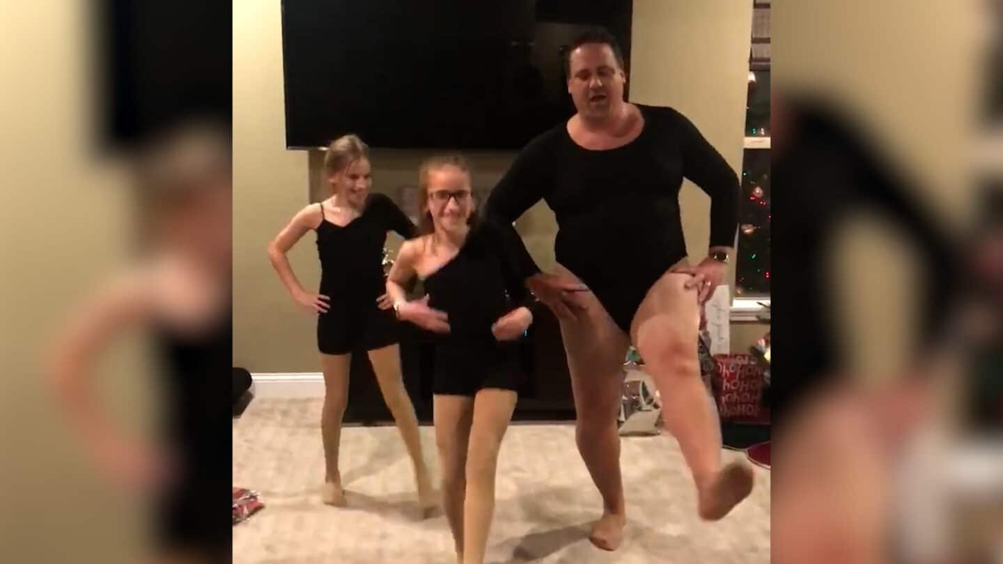 dad wearing a leotard and dancing with daughters