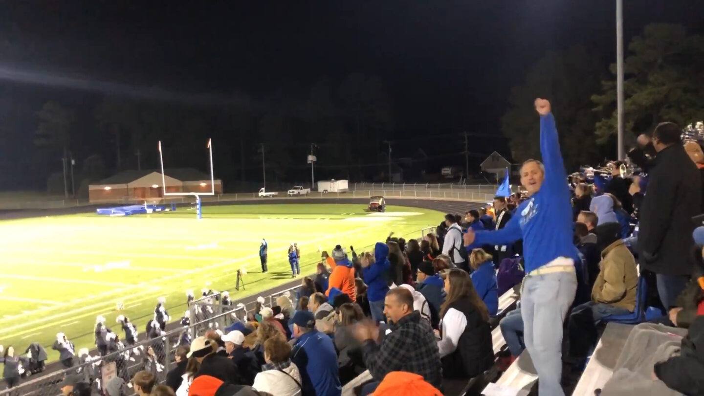 dad cheering on daughter at a football game