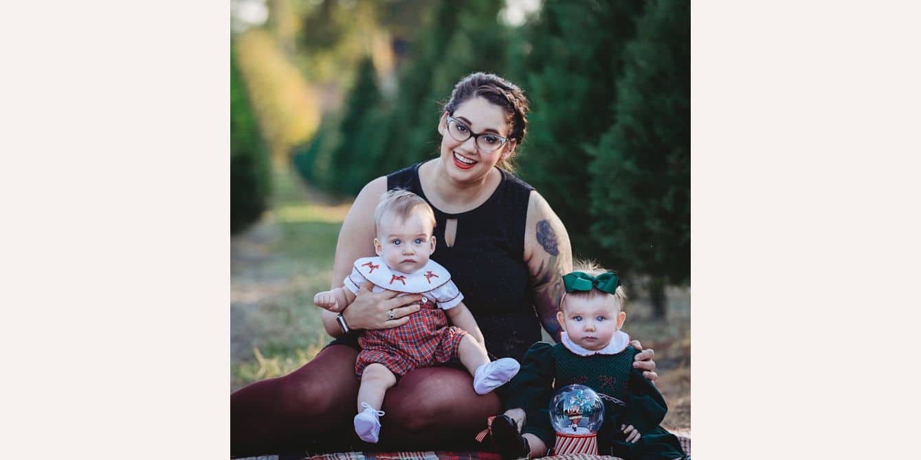 mom holding twins for a family photo - essay on getting out postpartum depression darkness