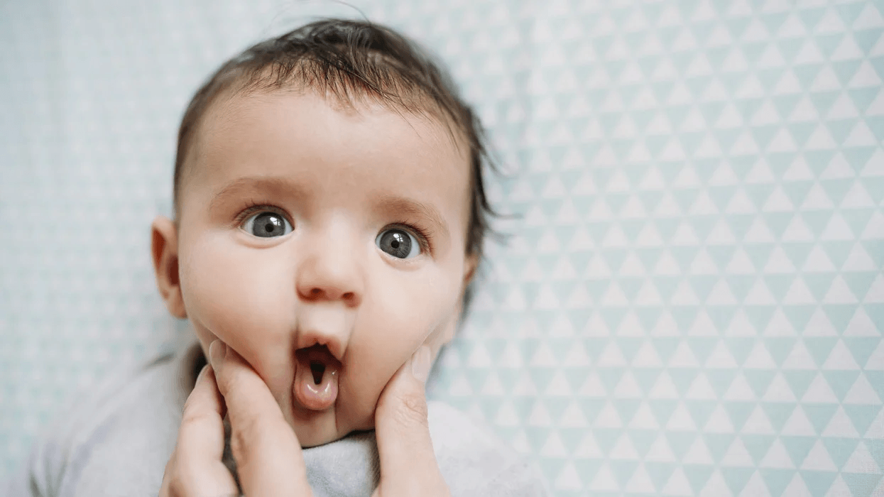 parent pinching baby's cheeks