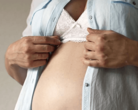 pregnant person looking at belly Motherly