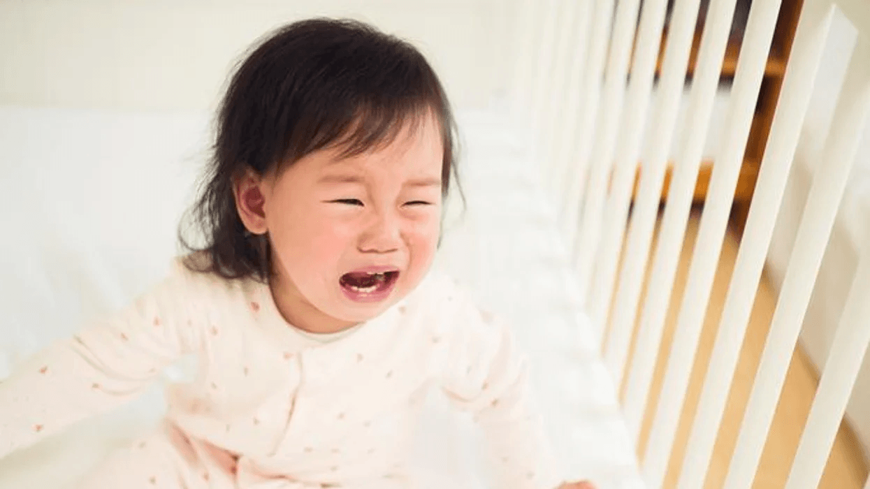 little girl crying in her crib