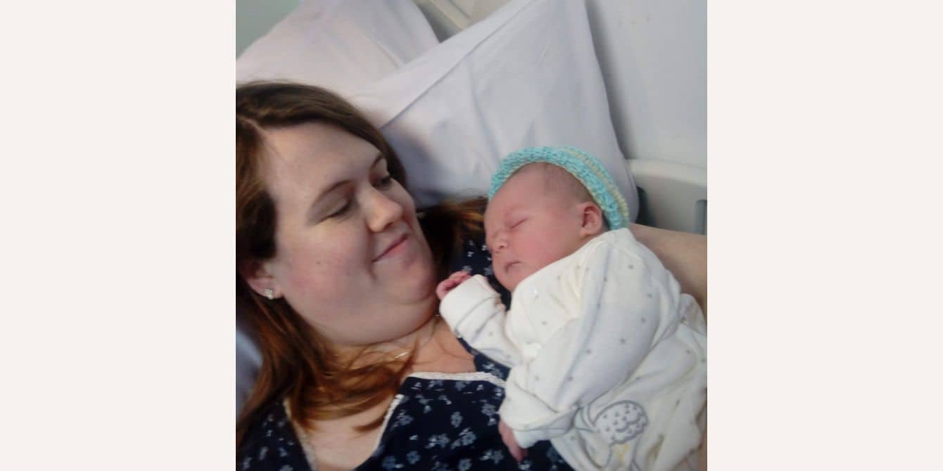 mom holding newborn in a hospital bed - essay on getting help after experiencing anxiety