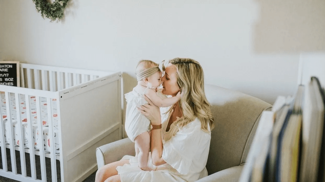 mom kissing baby in a nursery