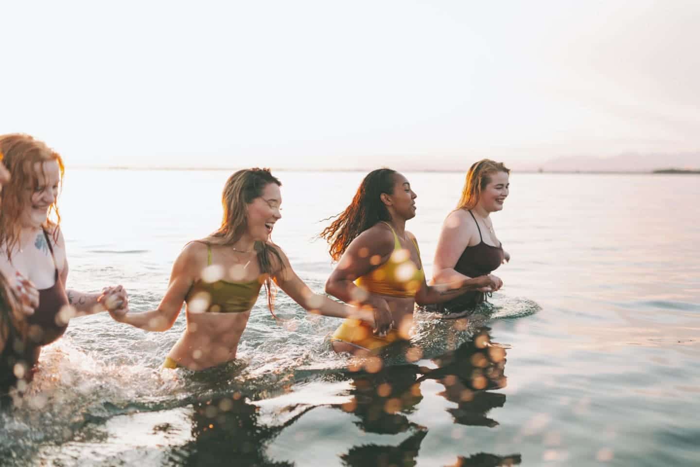 women-holding-hands-wading-in-the-ocean