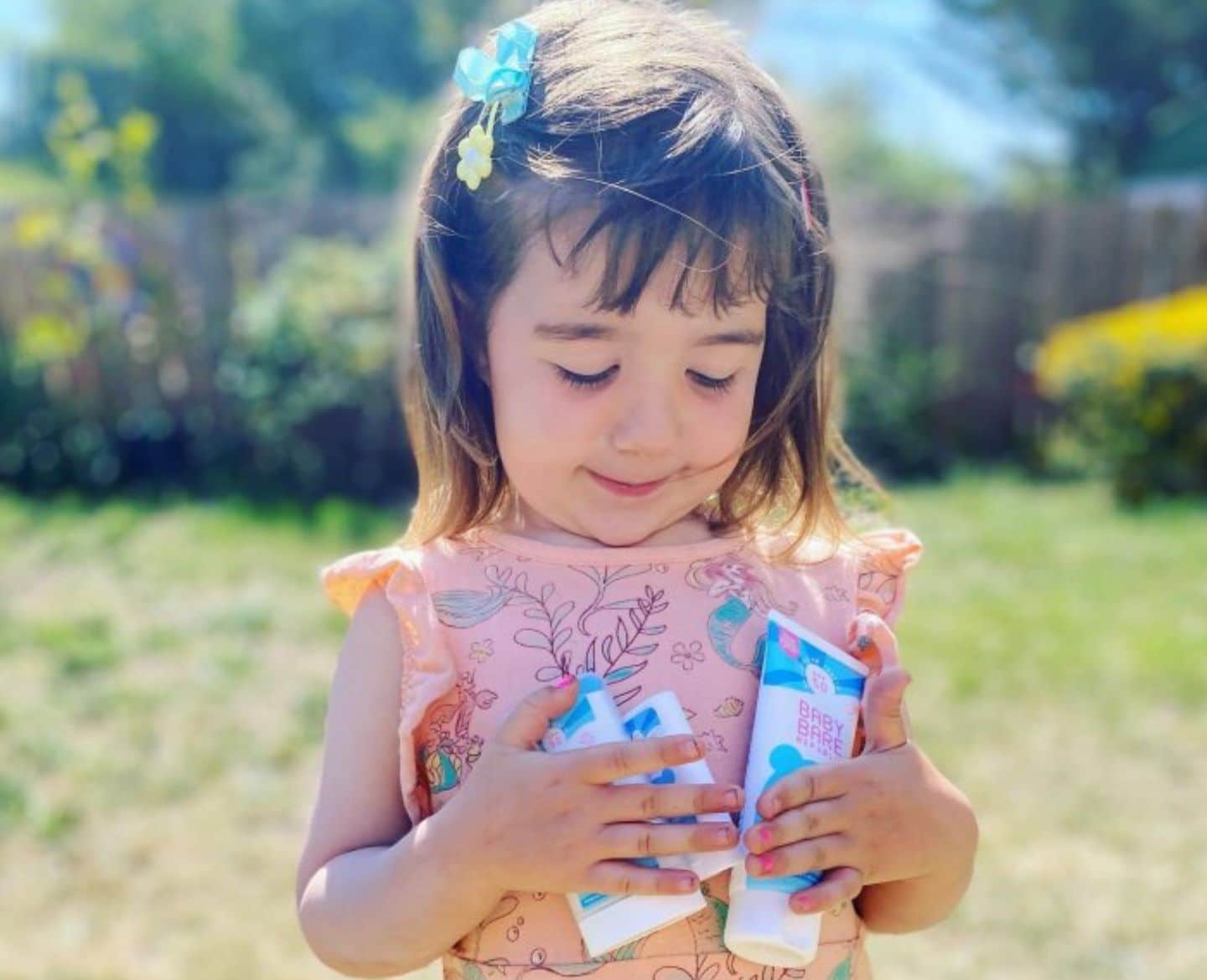 little girl holding sunscreen