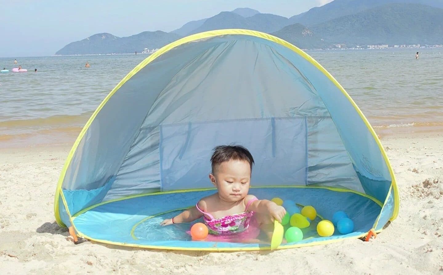 baby playing in a beach tent