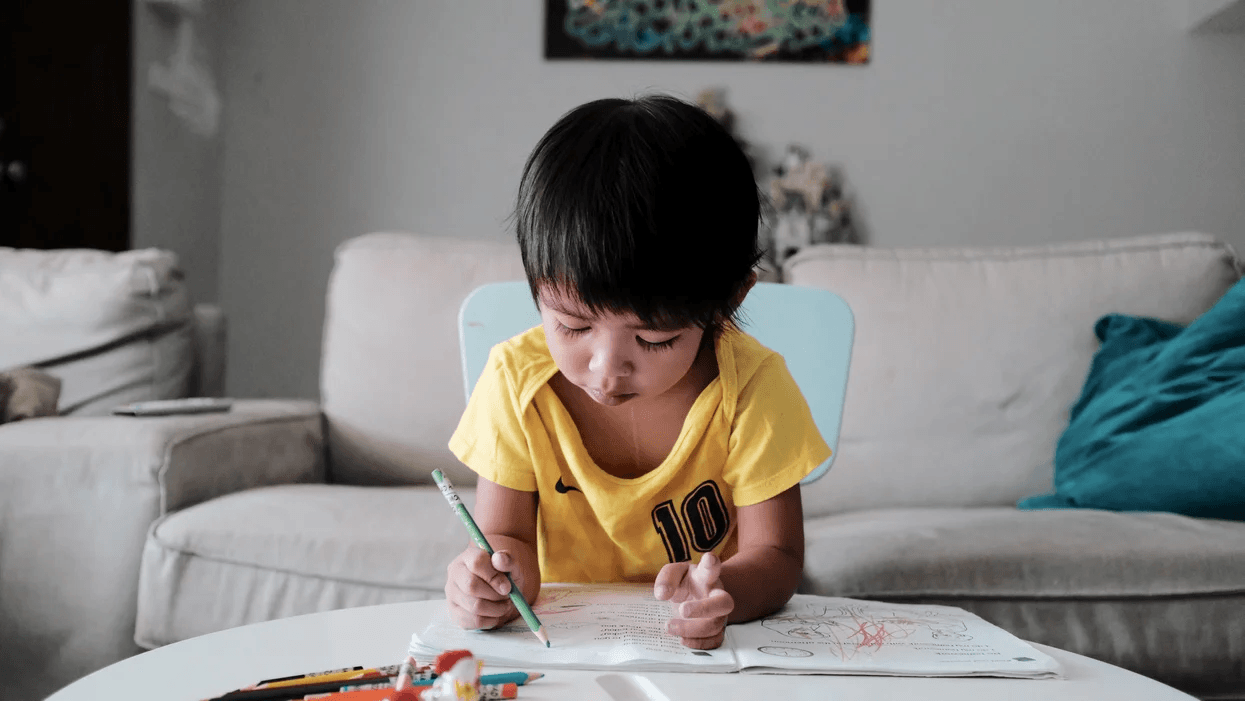 little boy coloring in the living room