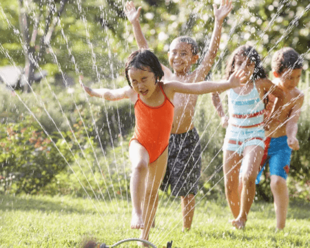 children running through sprinkler Motherly