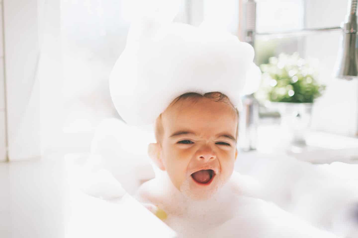 baby in a bubble bath, getting ready to play with montessori bath toys