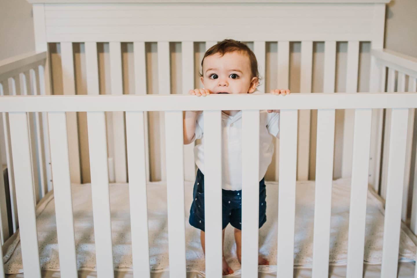 little-boy-standing-over-a-crib