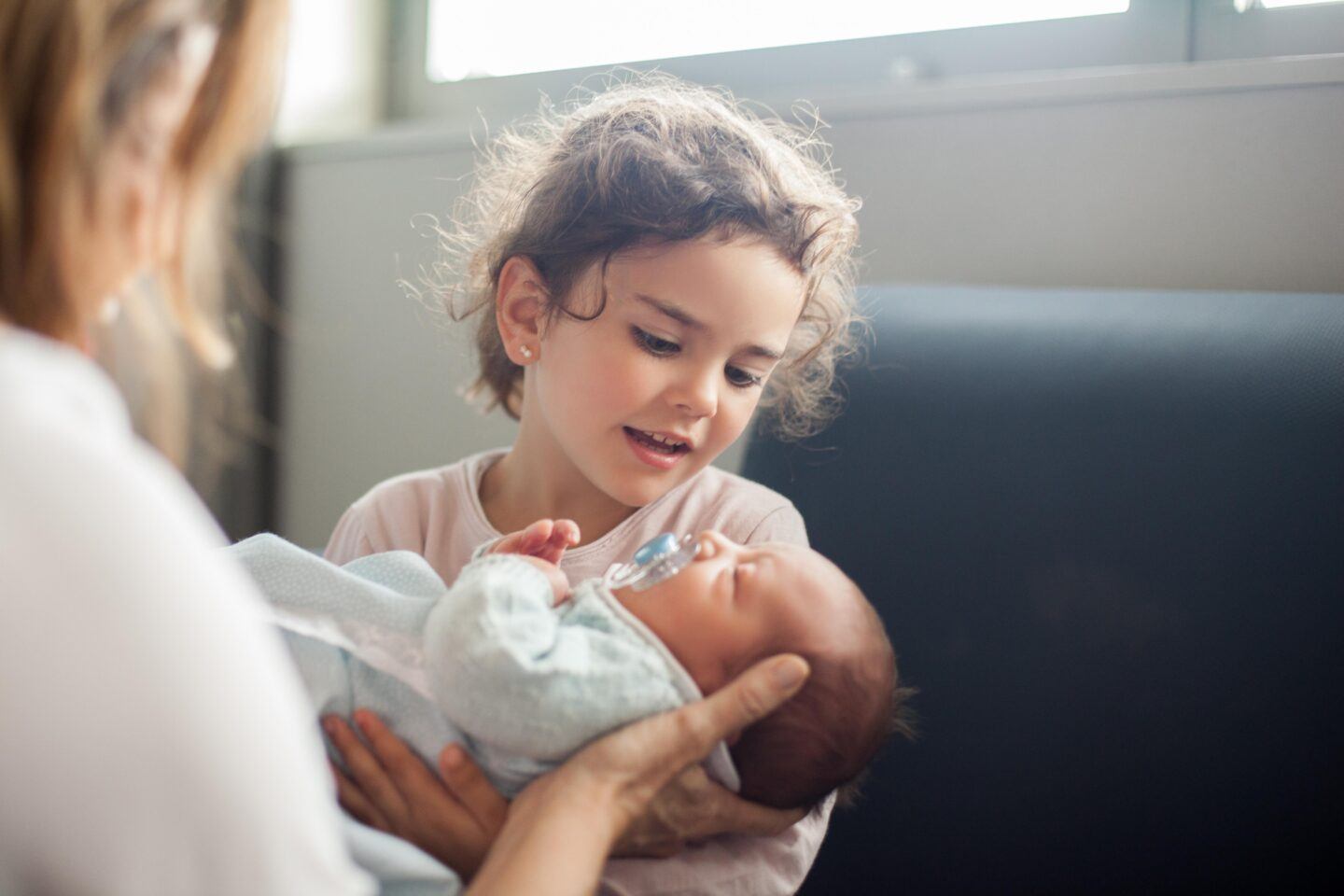 older sibling holding baby