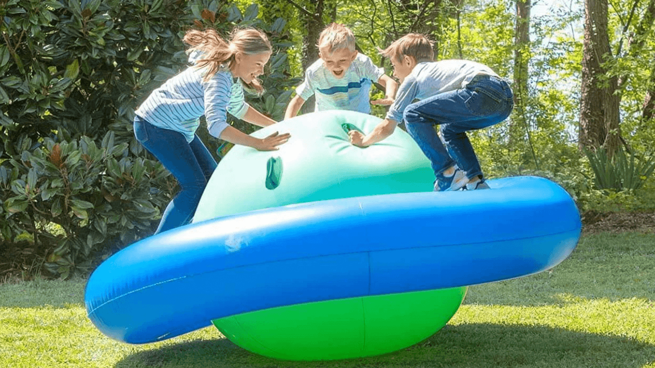 children playing on an inflatable tube outside