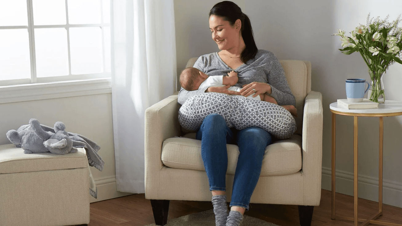 mom breastfeeding baby with a nursing pillow