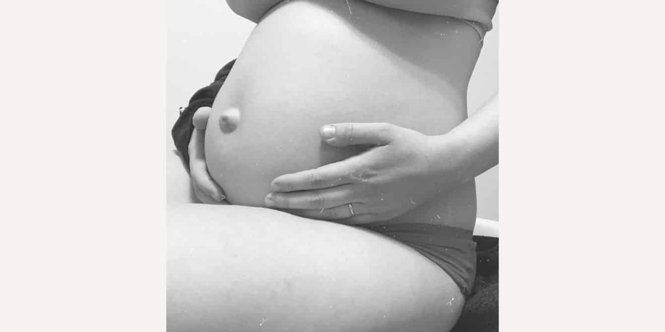 black and white photo of a pregnant belly - essay on prenatal depression