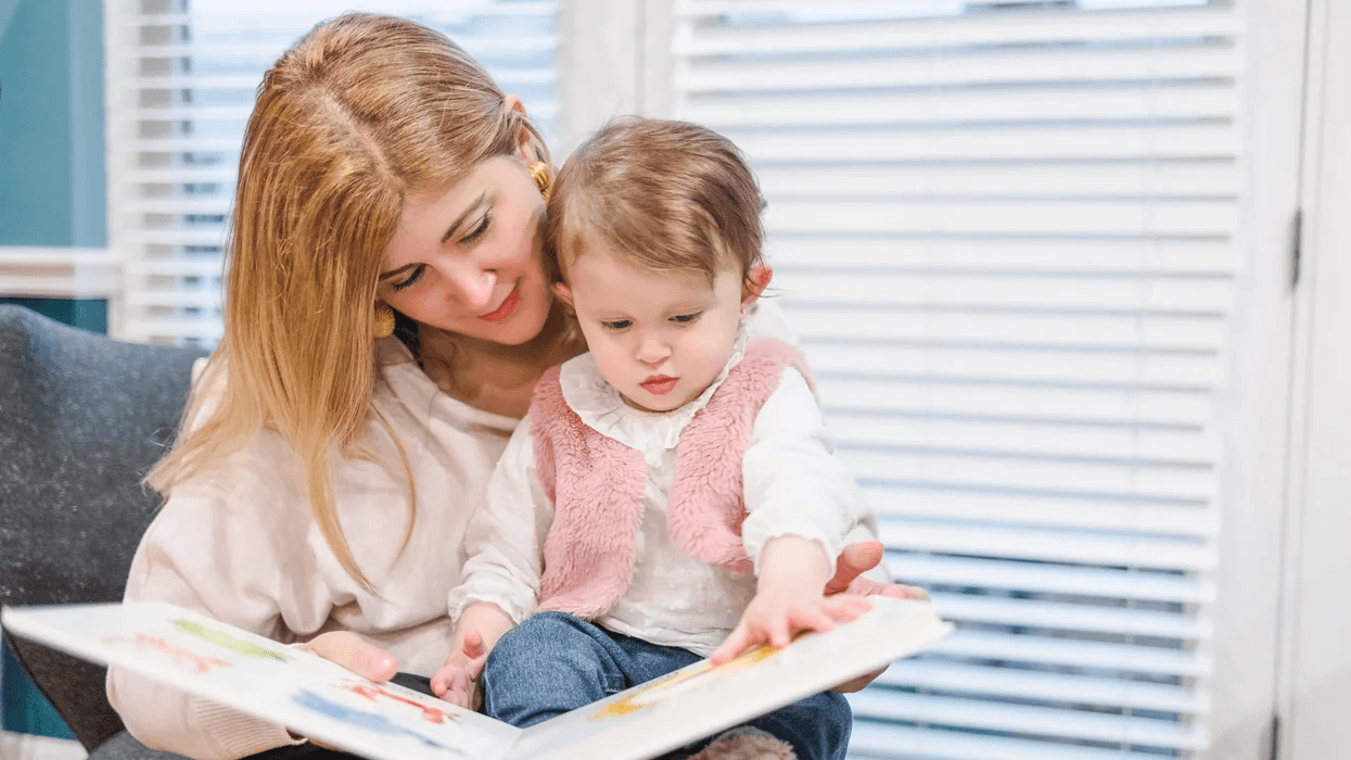 mom reading to daughter sitting on her lap