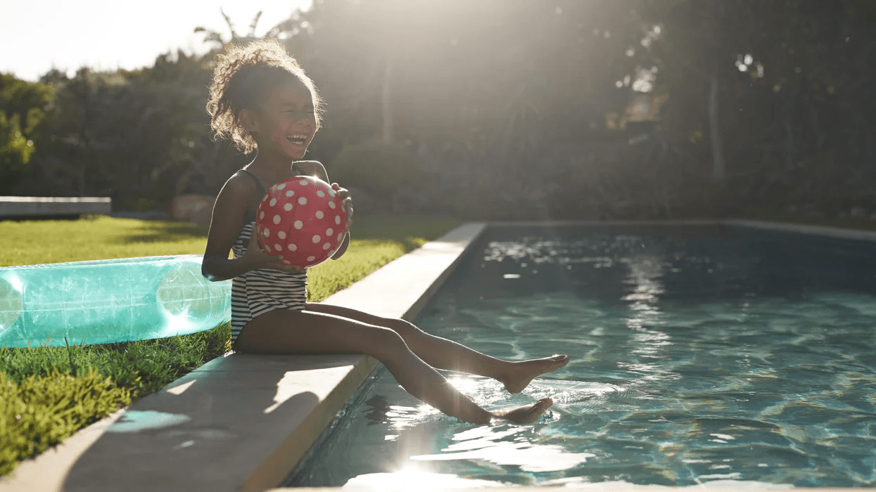 young girl laughing on the edge of a pool- swimming pool games