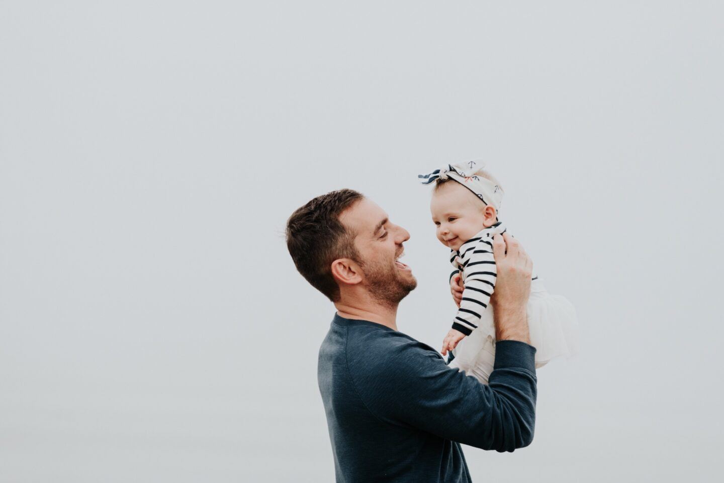 dad holding baby girl in the air