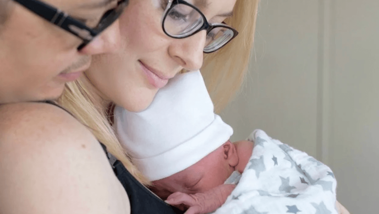 mom snuggling a newborn baby against her chest