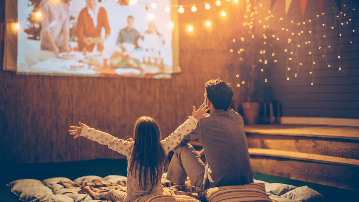 Father and daughter watching an outdoor movie