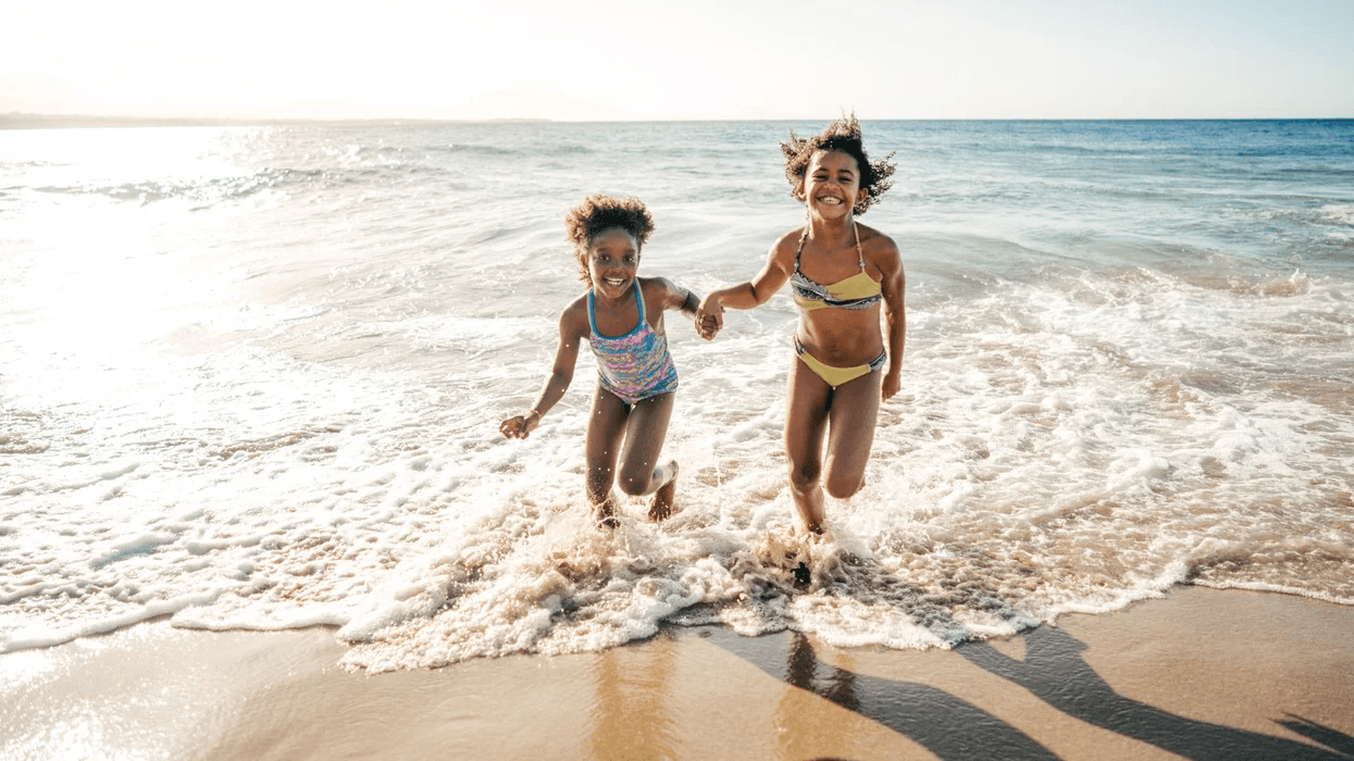 siblings running on the beach