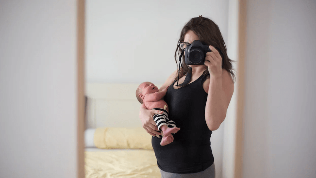 new mom taking a selfie holding newborn baby, ready to rock the 4th trimester