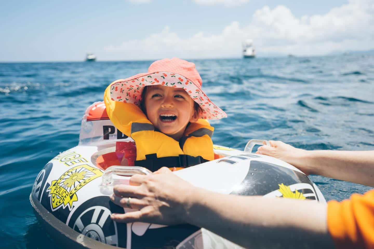 little girl smiling on a raft in the ocean