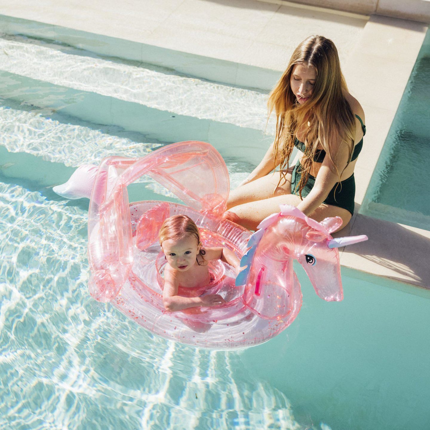 mom and child playing with inflatable pool toy