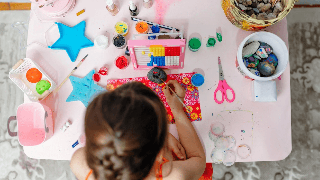 little girl painting rocks