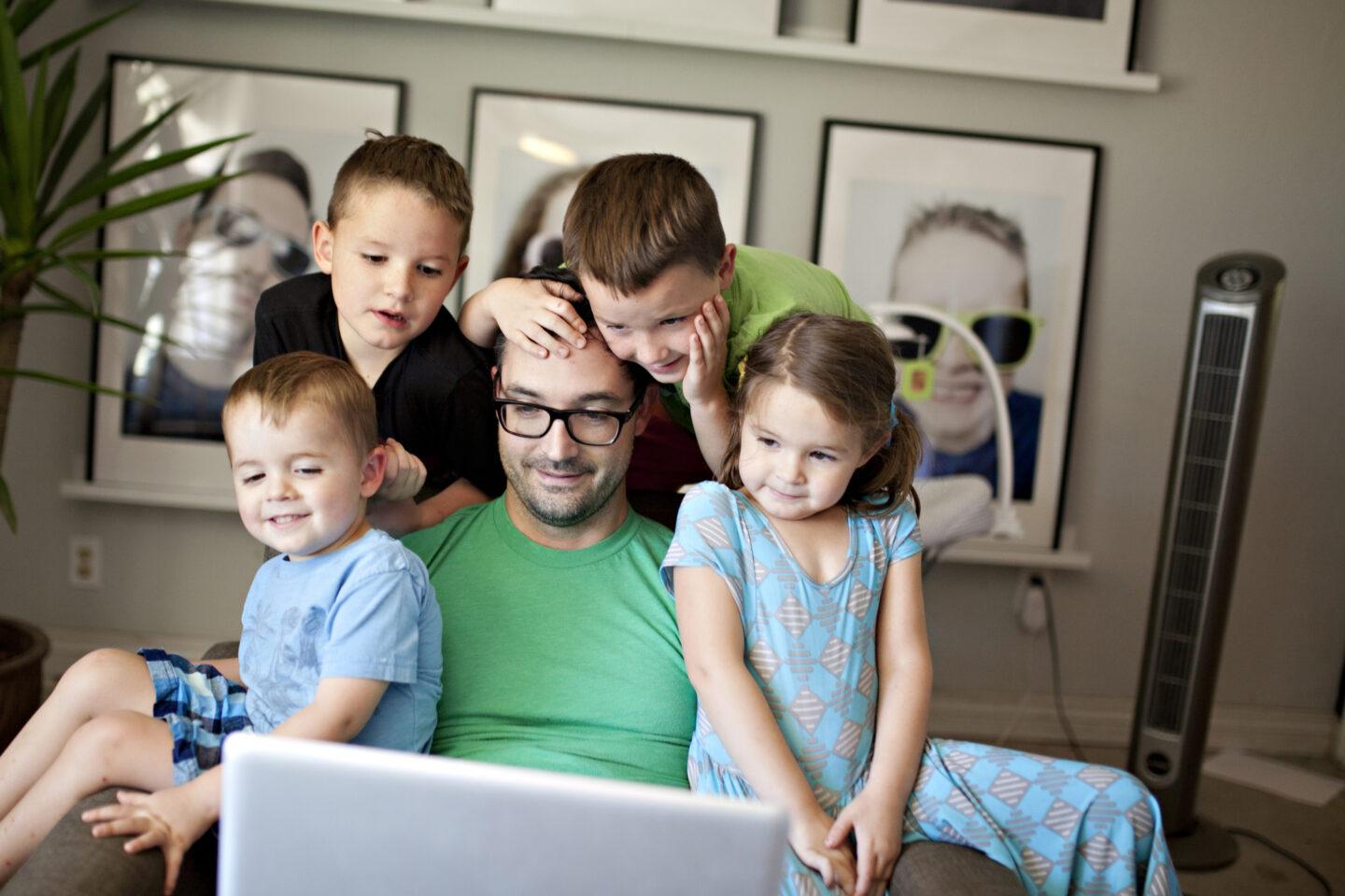 dad working with kids surrounding him