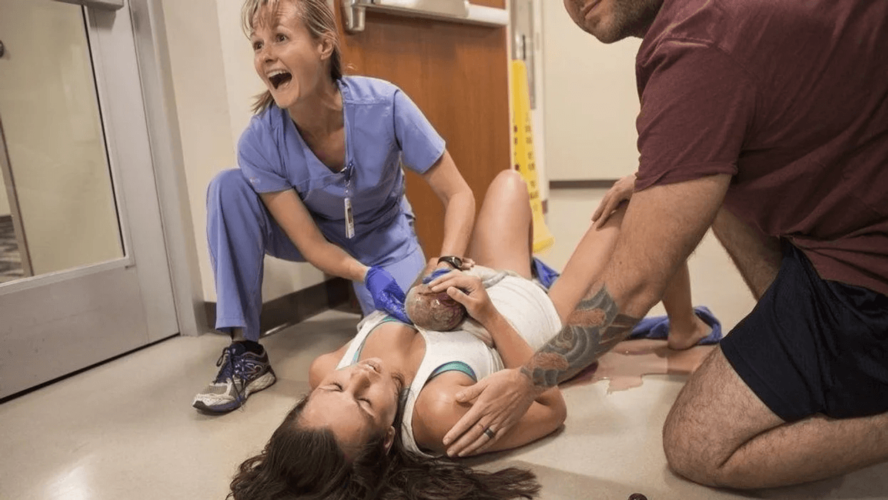mom laying on the hospital floor in a viral birth photo