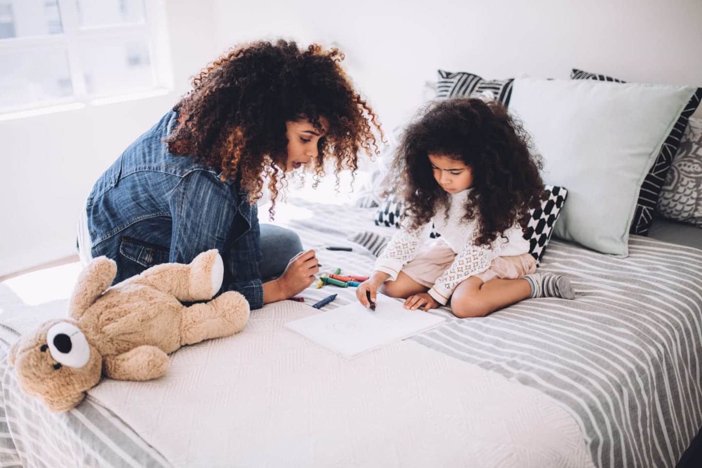 mom and child drawing on the bed