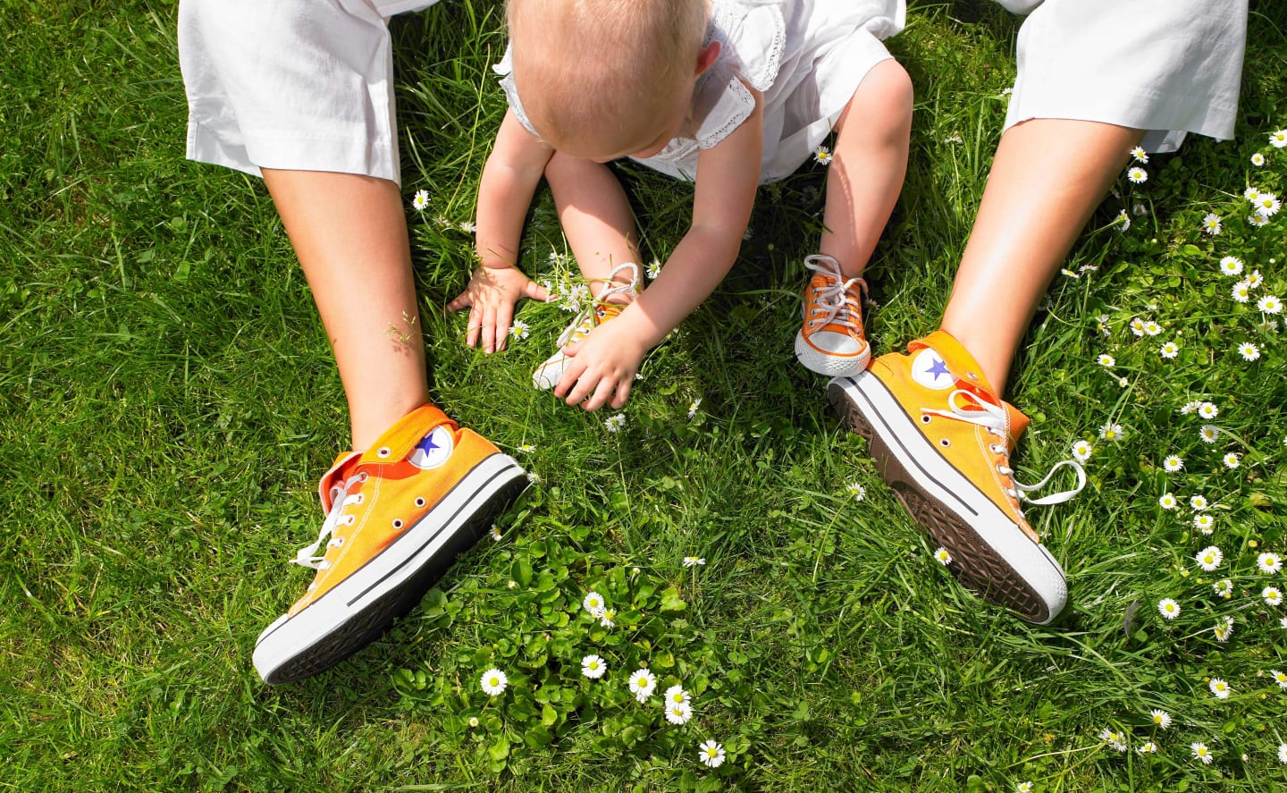 mom yellow chuck taylor shoes with child playing between her legs