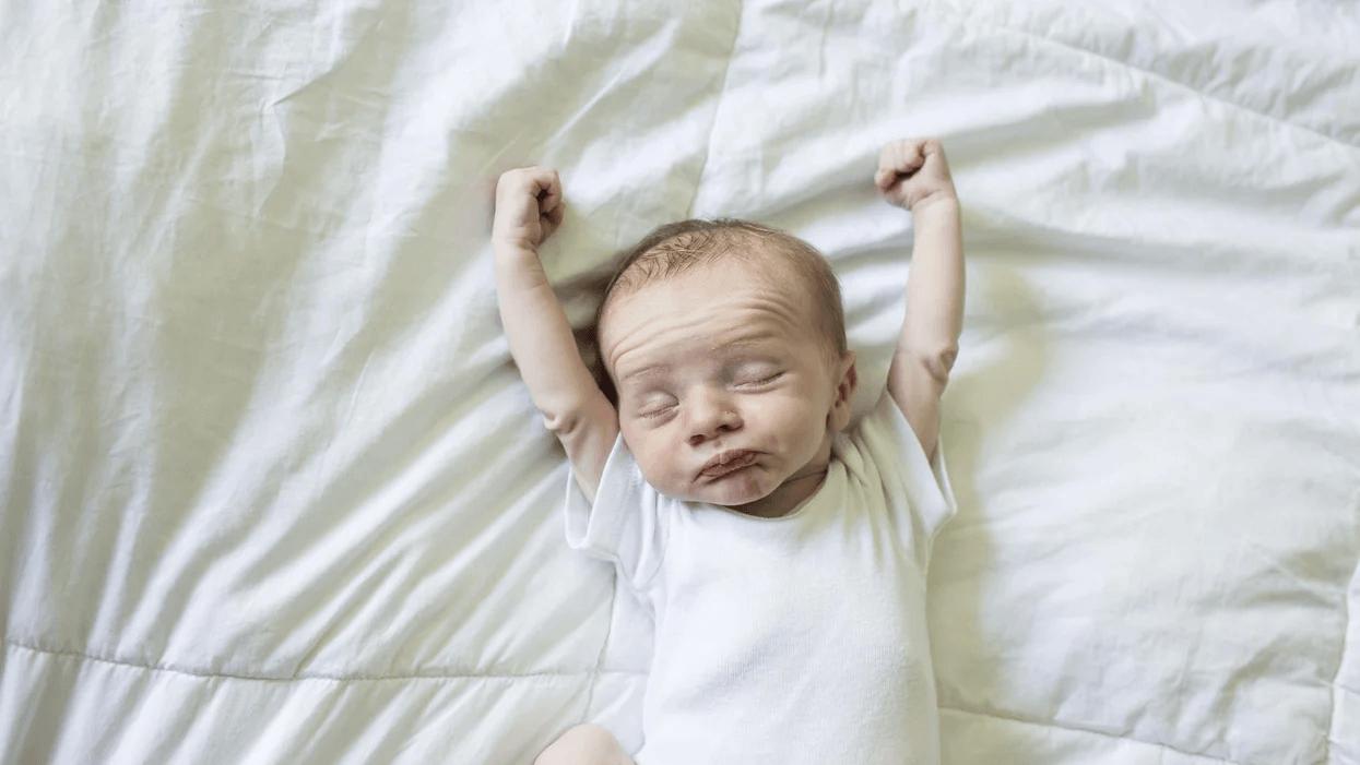 baby stretching on a bed - baby sleep schedule