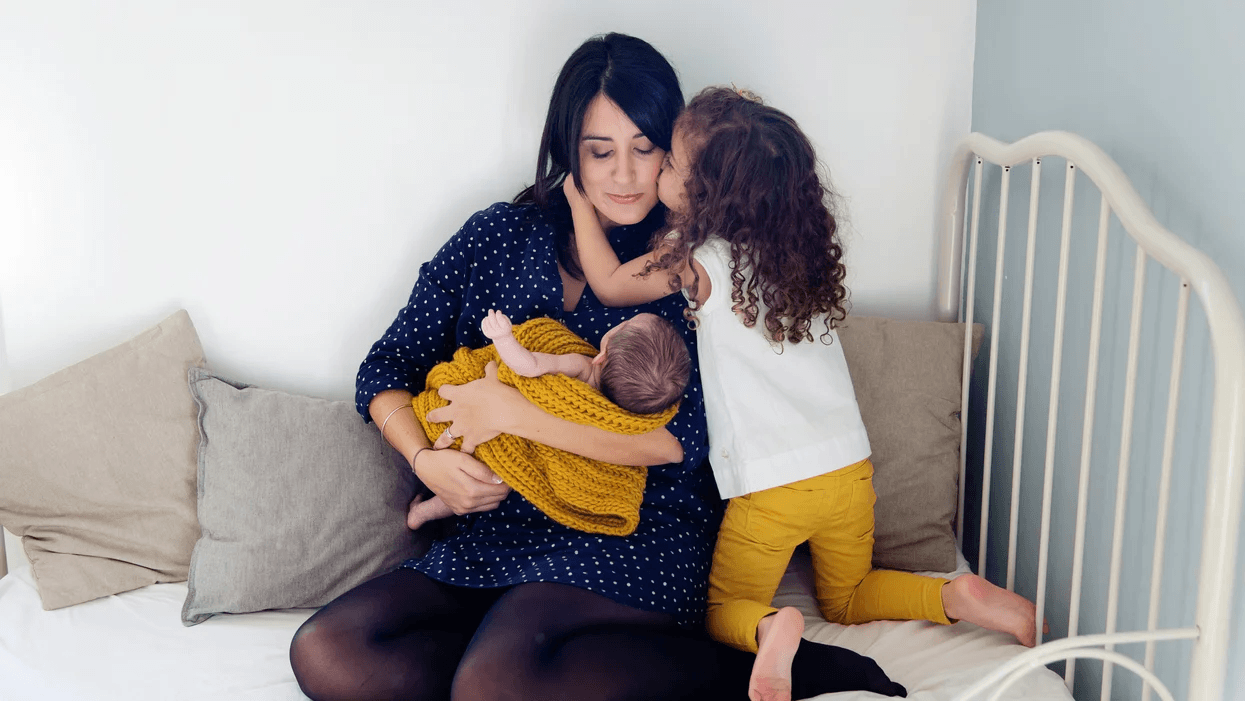 mom holding two kids