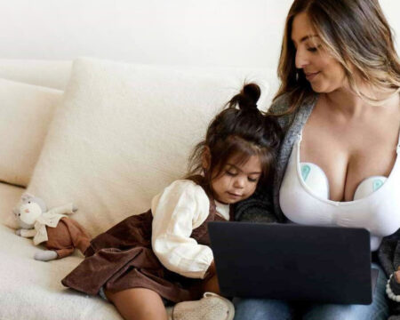 mom with baby and toddler wearing breastpump Motherly