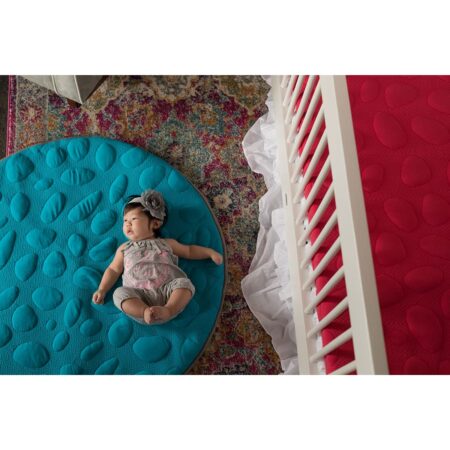 baby laying on teal play mat