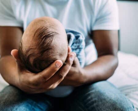 dad holding newborn baby contemplating foods that increase sperm count